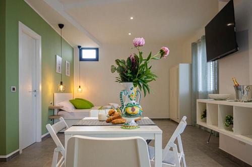 a living room with a table with a vase of flowers at Sunrise Luxury Apartments in Cassibile