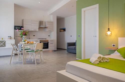 Sunrise Luxury Apartments في كاسيبيلي: مطبخ وغرفة معيشة مع سرير وطاولة