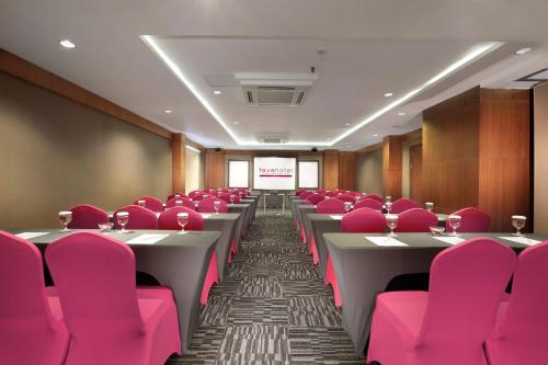 a conference room with pink chairs and tables at favehotel Sunset Seminyak in Seminyak
