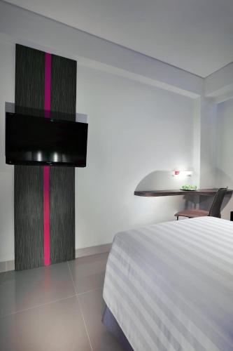 a bedroom with a bed and a black and pink wall at favehotel Sunset Seminyak in Seminyak