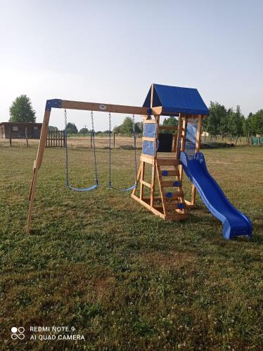a playground with a slide and a swing at APPARTEMENT LE DOMAINE DES LIBELLULES PROCHE WALIBI in Corbelin