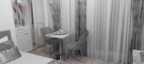 a room with a table and two chairs and a bed at City Lux Apartments in Skopje