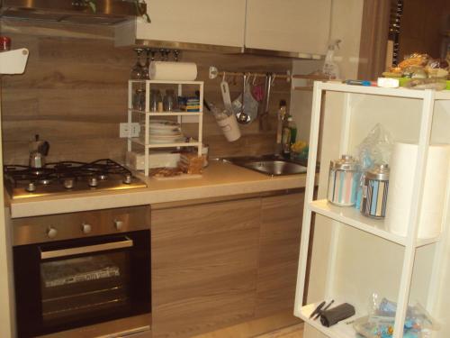 uma pequena cozinha com um fogão e um lavatório em Casa nel bosco em Livata