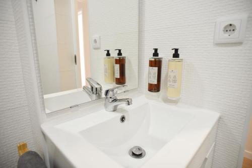 a bathroom with a sink with two bottles on it at Nia Azorean Apartments in Horta
