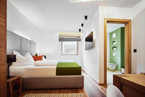 a bedroom with a bed with a green ottoman at Mountain Vita in Obertauern