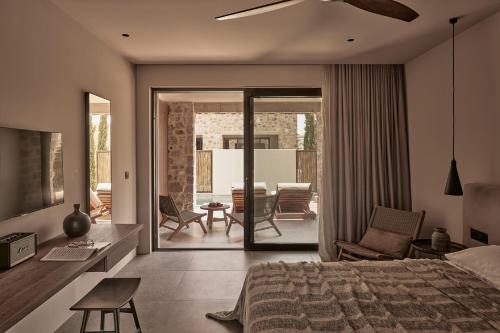 a bedroom with a bed and a living room at Theros All Suite Hotel - Adults Only in Kos Town
