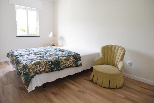 a bedroom with a bed and a chair at Nia Azorean Apartments in Horta