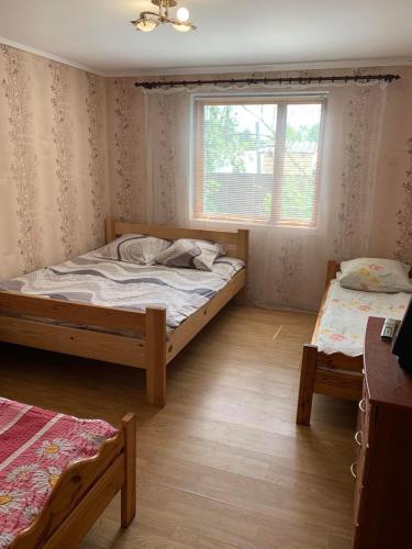 a bedroom with two beds and a window at Затока 1 in Svityazʼ