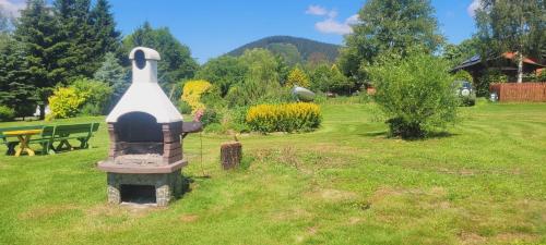 a park with a bird statue in the grass at Stanica pod Zadzierną Domki całoroczne in Lubawka