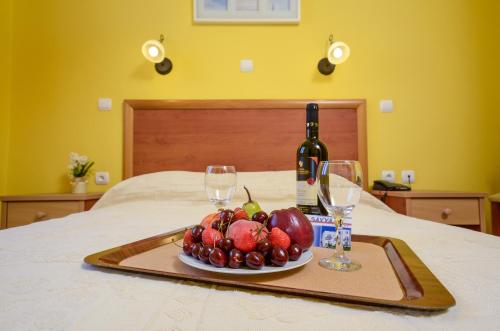 a tray of fruit and wine glasses on a bed at Naxos Hotel Savvas in Naxos Chora