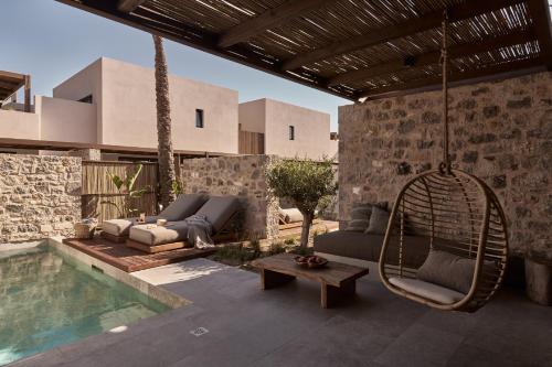 un patio con un columpio y una piscina en Theros All Suite Hotel - Adults Only, en Cos