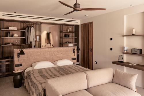 a bedroom with a bed and a couch at Theros All Suite Hotel - Adults Only in Kos Town