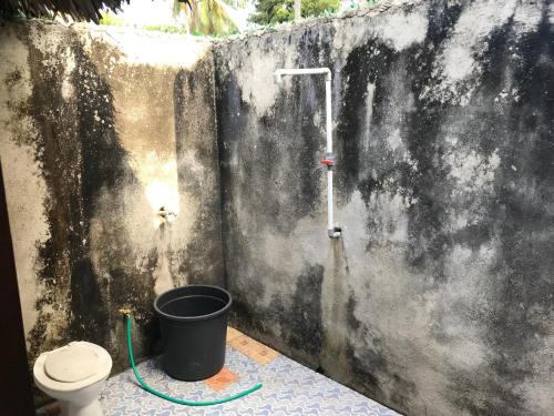 a bathroom with a toilet and a bucket at Talenta Mas Homestay in Nembrala