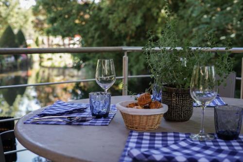 a table with two wine glasses and a bowl of food at Hostellerie De Levernois in Levernois