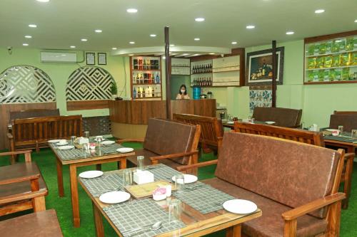 un ristorante con tavoli e sedie e una donna sullo sfondo di Kathway Hostel & Homestay a Kathmandu