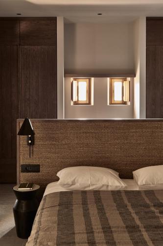 a bedroom with a bed with two lights above it at Theros All Suite Hotel - Adults Only in Kos Town