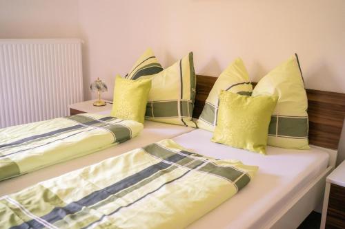 two beds sitting next to each other with yellow pillows at Appartments Kramer in Schiefling am See