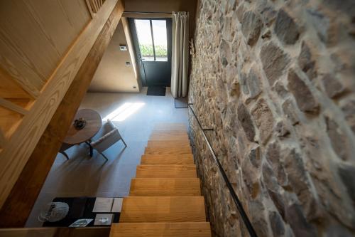 a staircase in a house with a stone wall at Paddock Lodge - Suites Wellness & Chambres d'hôtes in Stoumont