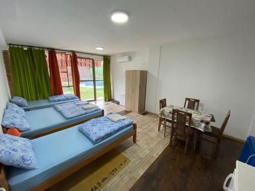 Zimmer mit 2 Betten und einem Tisch mit einem Tisch in der Unterkunft Hacijenda Gane in Sokobanja