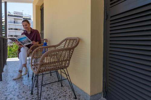 a woman sitting in a chair reading a book at Tinas Home - Kalamata Mediterranean Villas in Kalamata