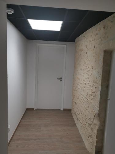 an empty room with a door and a wall at Logis Le Relais du Chapeau Rouge in Saint Loup Lamaire