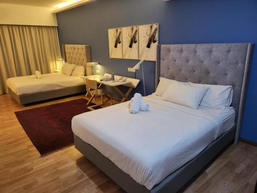 une chambre d'hôtel avec deux lits, une table et un lit dans l'établissement The Boutique Residence Hotel, à George Town