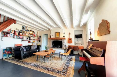 - un salon avec un canapé et un piano dans l'établissement La Maison Folia, à Contrières