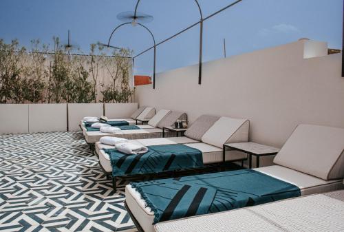 - un ensemble de chaises et de canapés sur une terrasse dans l'établissement Le Pavillon de la Kasbah & SPA Marrakech, à Marrakech