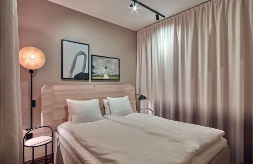 a bedroom with a bed and a lamp and curtains at Scandic Oceanhamnen in Helsingborg