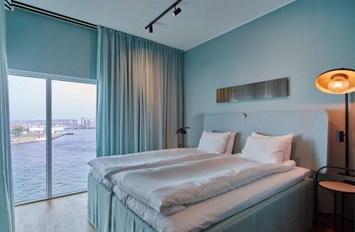 a bedroom with a large bed with a large window at Scandic Oceanhamnen in Helsingborg