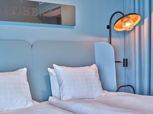 a bedroom with a white bed and a lamp at Scandic Oceanhamnen in Helsingborg