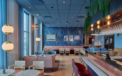 a restaurant with a bar and tables and chairs at Scandic Oceanhamnen in Helsingborg