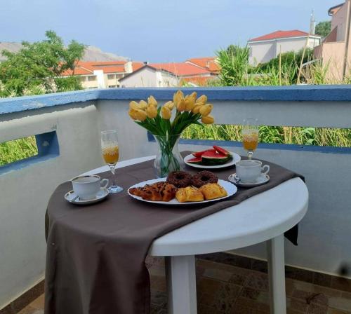 a table with a plate of food and two glasses of wine at Apartments MaRo in Pag