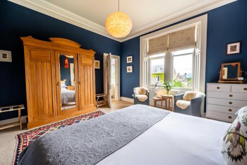 a bedroom with a large bed and blue walls at Washington House in Nairn