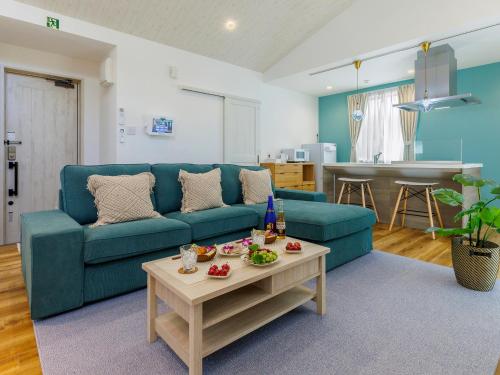 a living room with a blue couch and a table at la ohana～瀬底島～（2022年OPEN） in Okinawa City