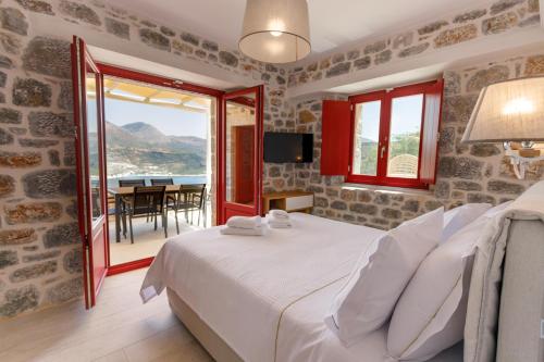 a bedroom with a bed and a view of the ocean at ATHINA-APEA Villas in Limeni