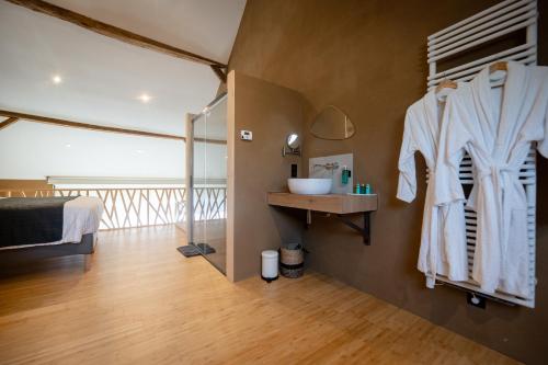 a bedroom with a bed and a sink in a room at Paddock Lodge - Suites Wellness & Chambres d'hôtes in Stoumont