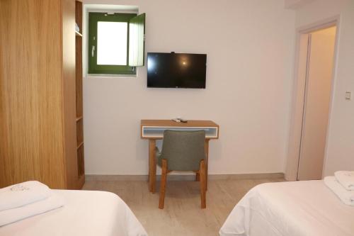 a room with a desk and a tv on the wall at ARIS-APEA Villas in Limeni
