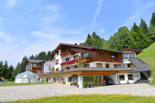 a large house with a greenhouse in front of it at Ferienwohnung Saalbach Fieberbrunn in Fieberbrunn