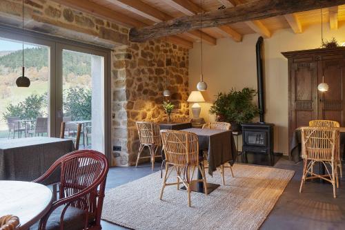 a dining room with tables and chairs and a stone wall at OAR Cottage in Durango