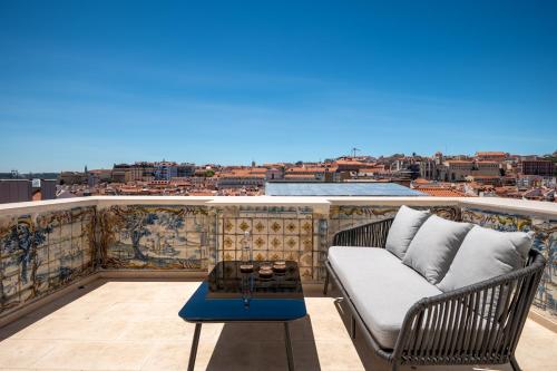 a living room filled with furniture and a balcony at Memoria Lisboa FLH Hotels in Lisbon