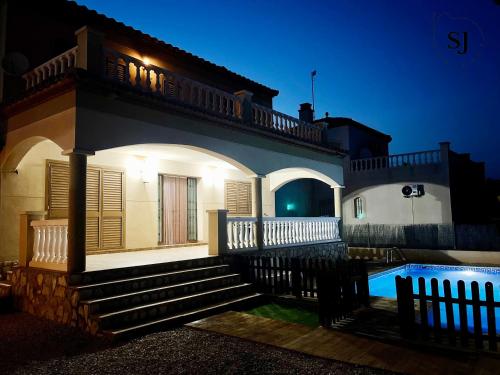 una casa con piscina di notte di Chalet con piscina (B) a Les tres Cales