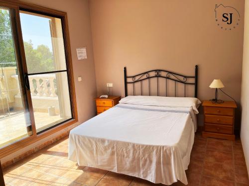 una camera da letto con un letto e una grande finestra di Chalet con piscina (B) a Les tres Cales