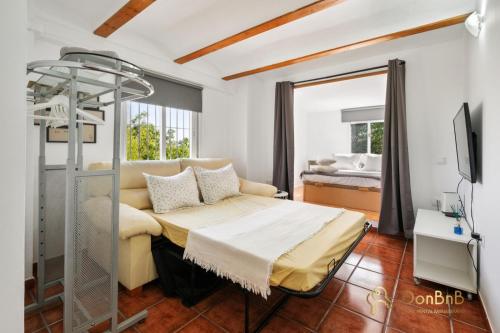 ein Schlafzimmer mit einem Bett und einem TV in einem Zimmer in der Unterkunft Casa de 2 dormitorios con piscina privada y desayuno incluido en Alhaurin in Alhaurín de la Torre