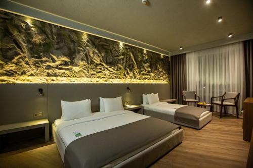 The Erzurum Hotel في أرزروم: غرفة فندقية بسريرين ولوحة على الحائط