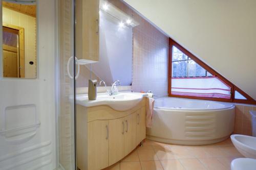 uma casa de banho com um lavatório, uma banheira e um WC. em Apartmaji Pri Handelčanih, Zreče em Zreče