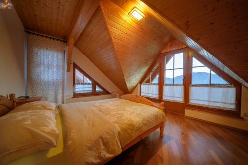 ein Schlafzimmer mit einem großen Bett im Dachgeschoss in der Unterkunft Apartmaji Pri Handelčanih, Zreče in Zreče