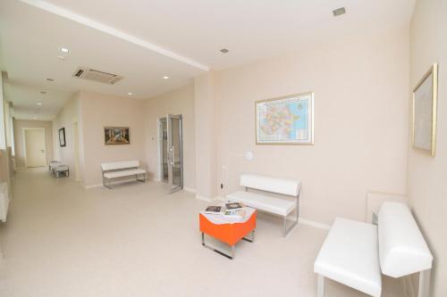a room with white furniture and a orange table at Chukhur Gabala Museum Hotel in Gabala