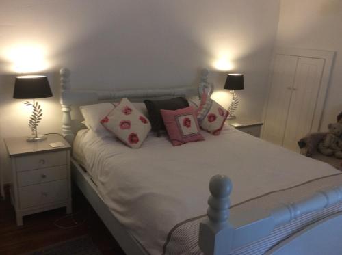 a bedroom with a bed with pillows on it at 1850s Character Stone Cottage in Mold