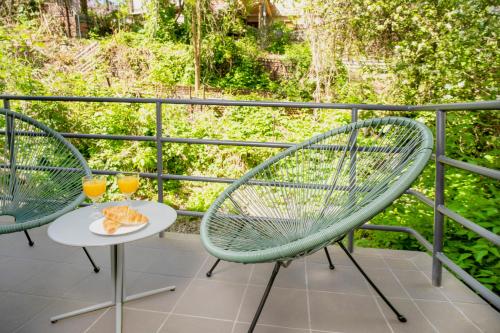 two chairs and a table with a plate of food on a balcony at House 22A Studio Apartments in Kaunas